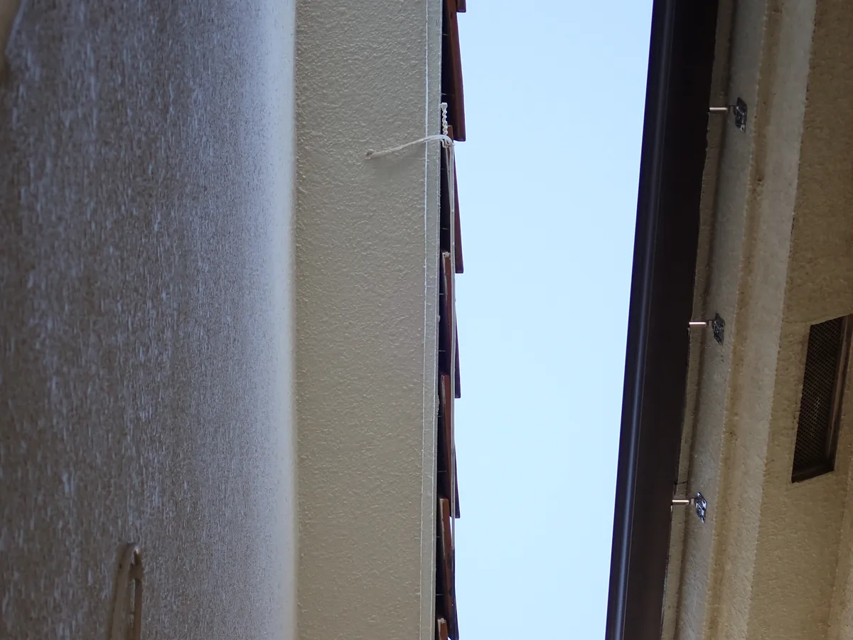 二つの建物の外壁にはさまれた細い空間を、下から空に向かって見上げた構図