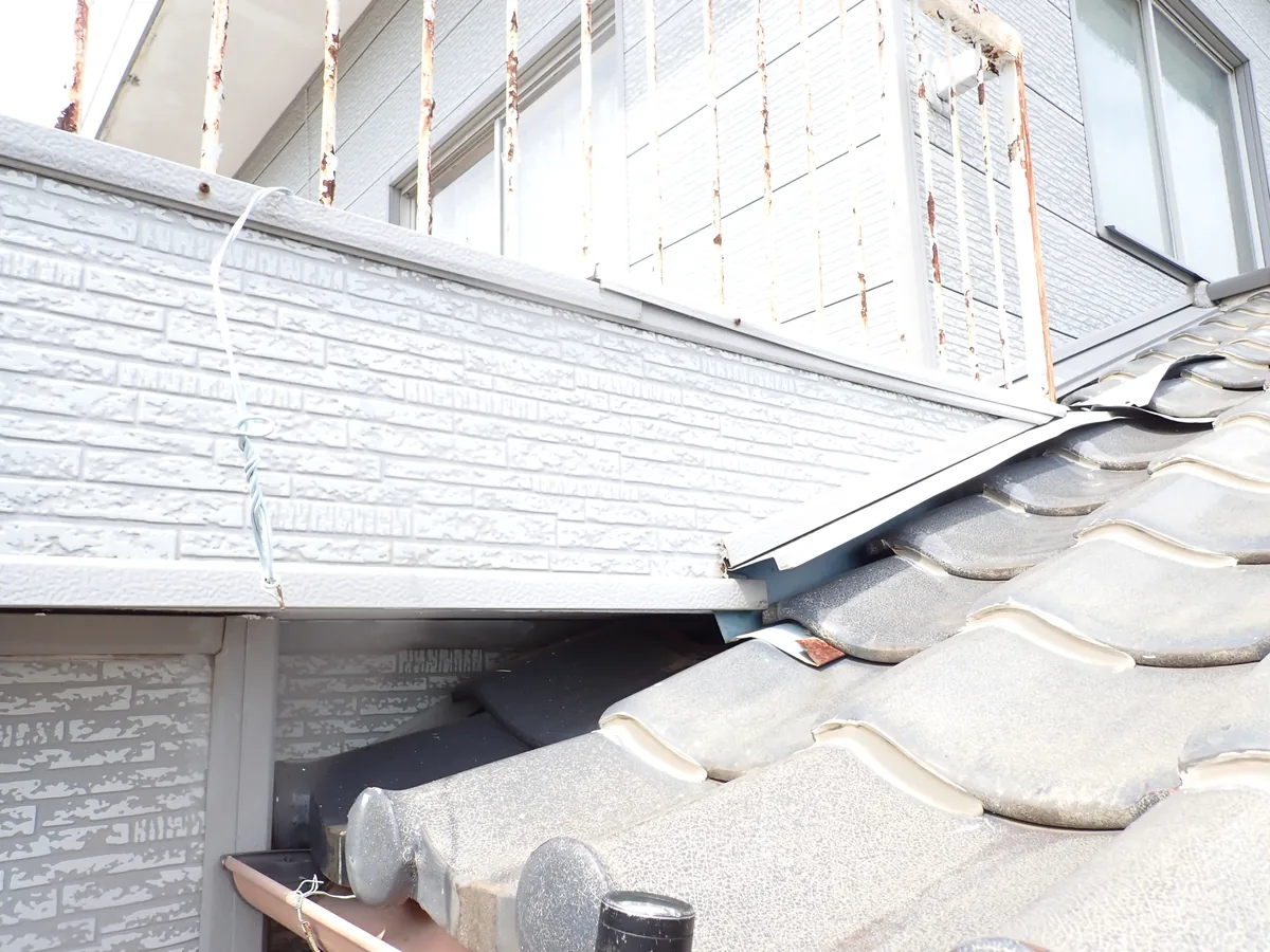 1階の瓦屋根が外壁に接する所で、板金がめくれて瓦との間に開いた隙間