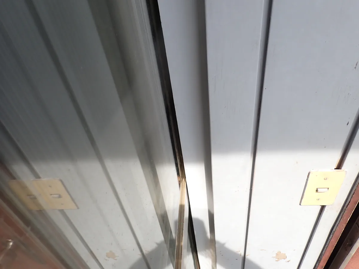 ガラス窓の脇で、金属製の雨戸との境に縦に続く細い隙間