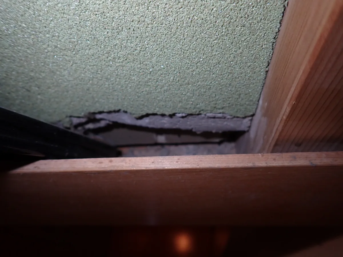 木枠に接する外壁の塗り材が剥がれ、下地との間にできた横長の隙間