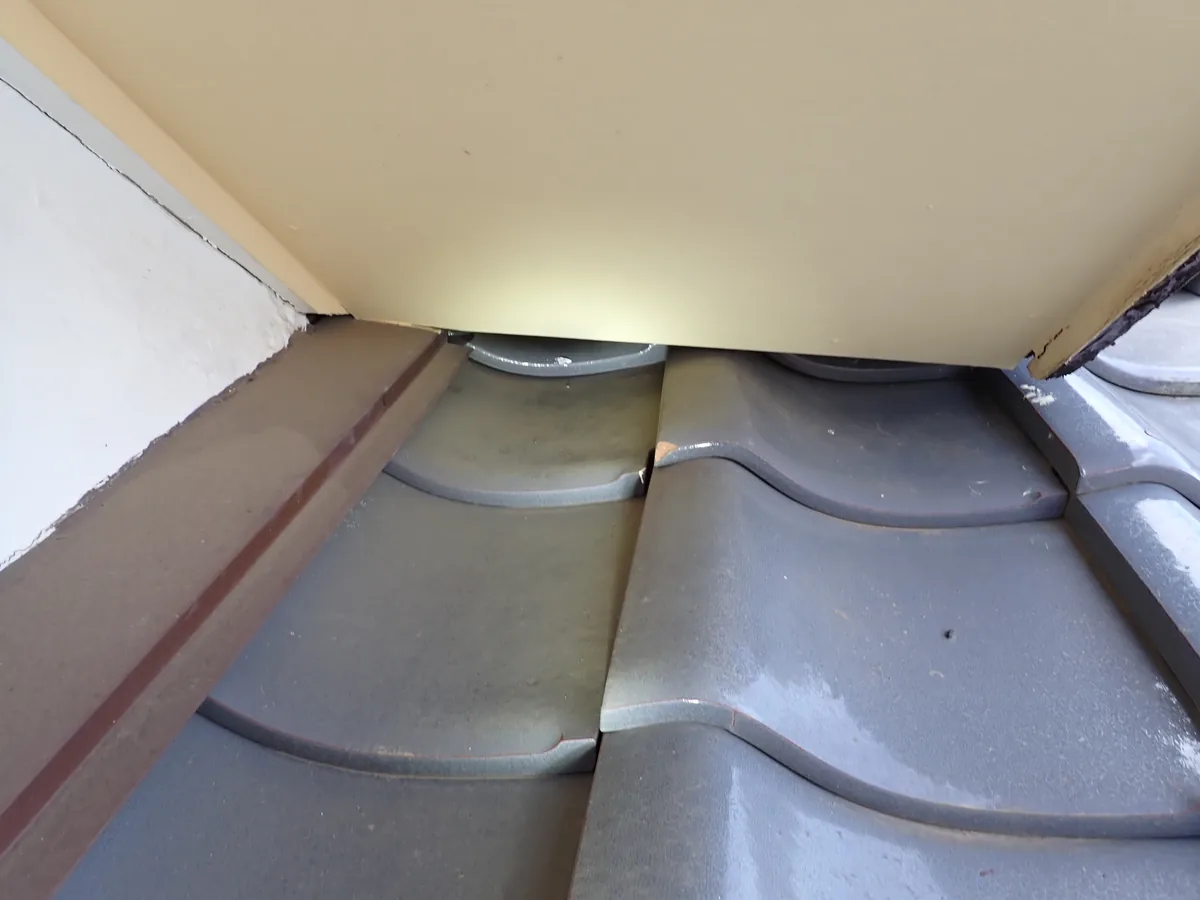 瓦屋根と、張り出した外壁の下端のあいだにできた、奥から光が見える隙間