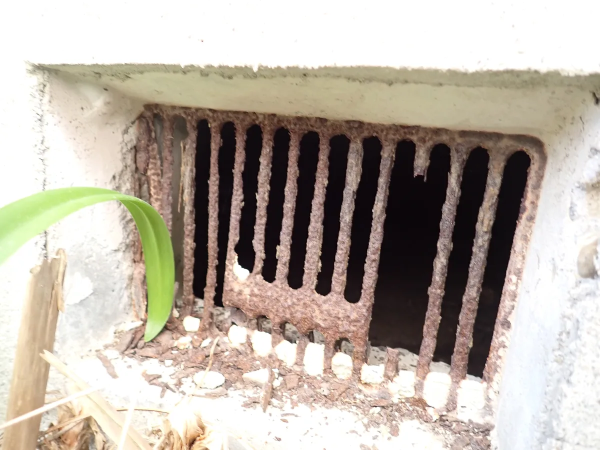 格子の一部が欠けて開口が広がった床下換気口